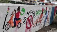 Salah satu mural warga di dinding turap Kali Sunter yang mengangkat tema keselamatan berkendara.