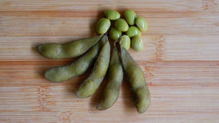 kacang kedelai Young soy beans. Known as edamame with wood background.