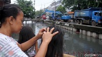 Proses pengerukan ini pun menjadi tontonan warga sekitar. Beberapa diantaranya menonton dari jembatan di depan rumah mereka.