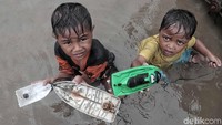 Mereka bermain perahu mainan.