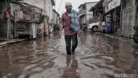 Sejumlah warga melintas di pemukiman yang tergenang air rob di kawasan Muara Angke, Jakarta Utara, Senin (21/1).