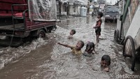 Mereka semakin senang, saat mobil yang melintas membuat gelombang pada permukaan air banjir.