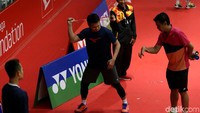 Seorang pelatih sedang mengarahkan strategi bermain kepada salah seorang atlet di tengah sesi latihan.
