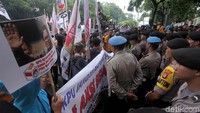 Polisi berjaga di depan gedung KPU RI. Ratusan pendemo itu terus menyampaikan aspirasinya dengan pengeras suara dari mobil komando.