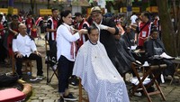 Herman memangkas rambut Jokowi di pinggir Danau Situbagendit, Garut, Jawa Barat pada Sabtu (19/1/2019). Saat itu, Jokowi berpartisipasi di acara cukur massal. Herman adalah langganan Jokowi sejak masih menjabat sebagai Gubernur DKI Jakarta. Dia adalah pria asal Bantarjati, Garut. Jadi sebenarnya bisa dikatakan Herman adalah tukang cukur asgar, alias asli Garut. (Foto: ANTARA FOTO/Puspa Perwitasari)
