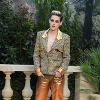 Setelan berjas menjadi andalan Kristen Stewart di peragaan rumah mode ternama di dunia itu. Ia memakai blus bersiluet blazer yang dipakai tanpa dalaman dengan celana panjang emas ombre berbahan satin yang mengilap.  Foto: Getty Images