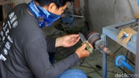 Pekerja tengah menyelesaikan proses pembuatan pisau seni.