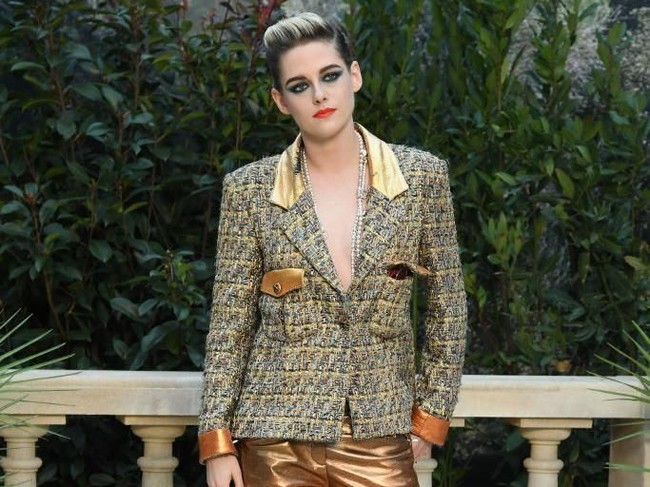 Di jajaran aksesori, ia mempercantik gayanya dengan kalung mutiara panjang, berikut kacamata berwarna oranye.  Foto: Getty Images