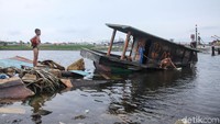 Mereka terlihat bermain di sekitar kapal yang telah karam di sekitar kawasan Muara Baru.