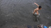 Seorang terlihat sedang bermain di pesisir Muara Baru, Penjaringan Jakarta Utara, Selasa (22/1/2019).