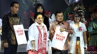 Jokowi dan JK memamerkan buku pemberian Megawati.