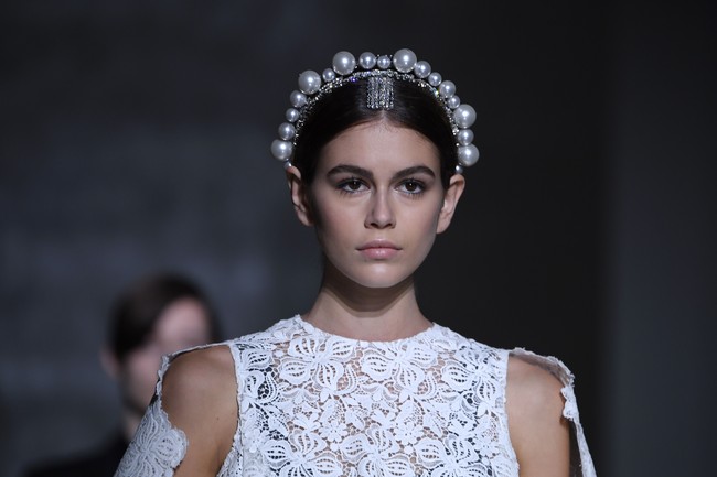 Tidak ketinggalan, sebuah mahkota yang dihiasi jajaran bola-bola mutiara turut menyempurnakan gaya model 17 tahun ini. Bak ratu, Kaia sukses menebar pesonanya di catwalk. Adalah Clare Waight Keller, direktur kreatif Givenchy yang merancang koleksi tersebut. Clare sempat menjadi sorotan saat terungkap bahwa dirinya yang mendesain gaun pengantin Meghan Markle tahun lalu. (Foto: Getty Images)