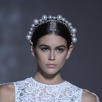 Koleksi adibusana terbaru Givenchy yang membungkus tubuh Kaia Gerber berupa atasan putih berbahan lace dalam siluet A yang jatuh di atas paha. Bergaya sleeveless atau tanpa lengan, busana tersebut dilengkapi sayap yang menjuntai dari bahu. (Foto: Getty Images)