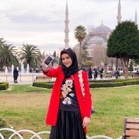Setelah beribadah umrah, Cut Meyriska juga mengunjungi Turki. Saat berjalan-jalan di sana, ia tampil cantik memakai hijab bergaya kasual. Ia memadukan T-shirt Mickey Mouse dengan coat warna merah dan rok pleats. Foto: Instagram/CutRatuMeyriska