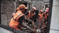 Terlihat petugas PPSU mengangkut sisa sepeda motor yang hangus terbakar.