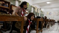 Para siswa yang tengah belajar di ruang kelas mengikuti beragam instruksi yang diberikan untuk menyelematkan diri saat terjadi gempa.