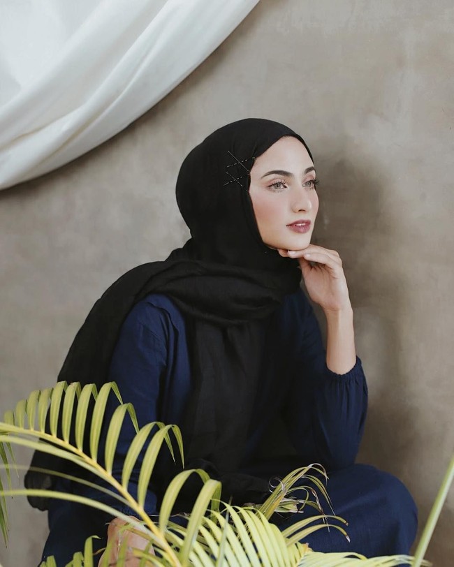 Munira memasang jepit rambut di satu sisi hijabnya. Ia menyilangkan jepit rambut tersebut di beberapa bagian, sehingga hasil akhirnya seperti corak atau motif yang menempel di pashminanya. Foto: Melody Madeas