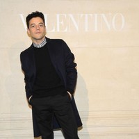 Rami Malek bersolek dengan gaya maskulinnya. Kemeja bermotif geometris yang dibungkus sweater hitam dan blazer panjang biru navy sebagai luaran menjadi busana andalan pria 37 tahun itu. Tidak ketinggalan, celana panjang hitam dan sepasang boots berwarna senada. (Foto: Getty Images)