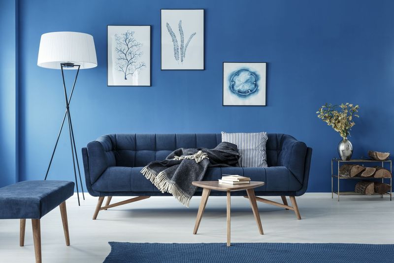 Simple bedroom with double bed, blue bedding, posters and window