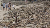 Wisatawan mancanegara melintas di dekat tumpukan sampah yang berserakan di kawasan Pantai Kuta, Badung, Bali, Rabu (23/1/2019).