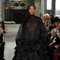Di fashion show tersebut, Kaia juga bersandingan dengan senior yang juga teman ibunya, Naomi Campbell. Sudah jarang berlenggang di catwalk, Naomi menebar pesonanya dalam balutan gaun hitam bersiluet megar dengan rok yang penuh ruffle di akhir peragaan. Gaun adibusana karya Pierpaolo Piccioli itu hadir dengan bagian bodice menerawang sehingga mengekspos tubuh Naomi yang tidak dibaluti dalaman. (Foto: Getty Images)