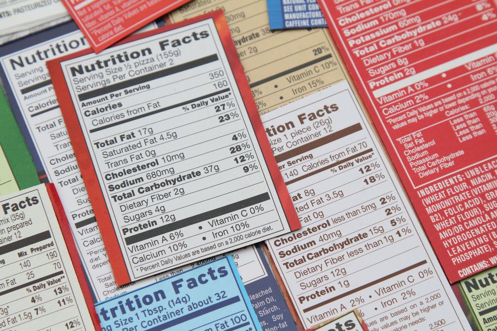 Various nutrition labels for a variety of packaged food products. Labels show calories, fat content, cholesterol, carbohydrates, protein, sodium, sugars, daily recommended litmits, vitamins and specfic ingredients in the foods. Prominent top label shows a whopping 680 mg soldium in the food product.