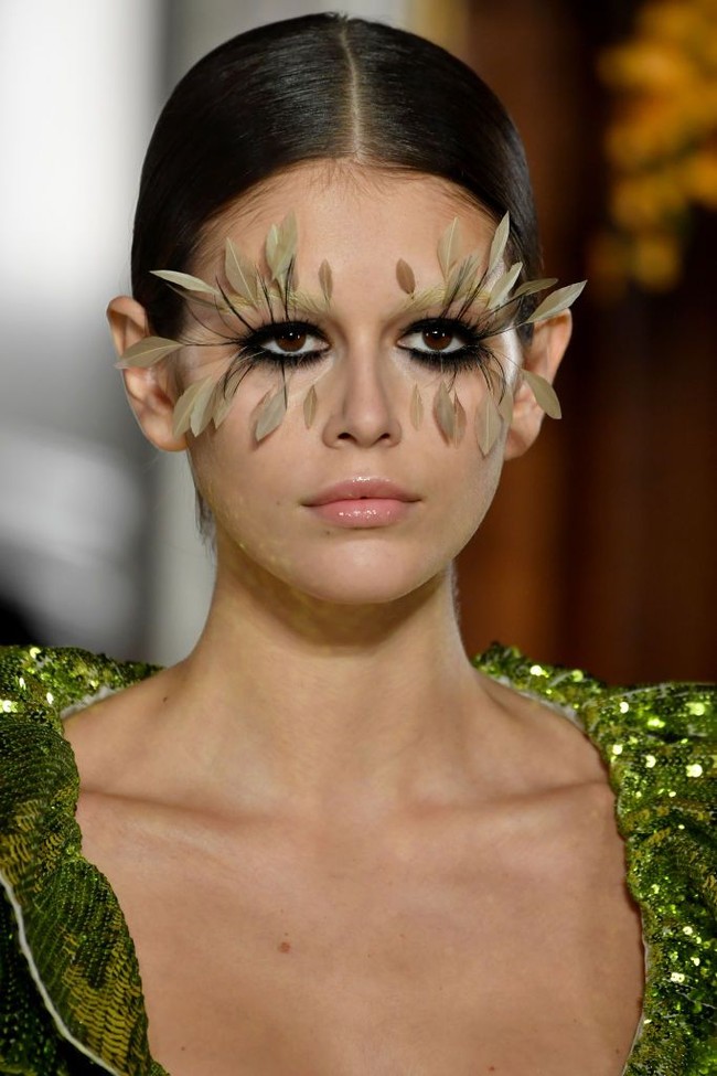 Gaya Kaia semakin dramatis berkat riasan wajahnya. Pat McGrath, makeup artist ternama andalan Valentino, mengaplikasikan bulu mata palsu yang bentuknya seperti bulu burung pada Kaia dan beberapa model lainnya. Dengan bulu mata tersebut, putri supermodel CIndy Crawford tampil beda dan hampir sulit dikenali. (Foto: Pascal Le Segretain/Getty Images)