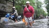 Beberapa warga nekat menerobos genangan air.