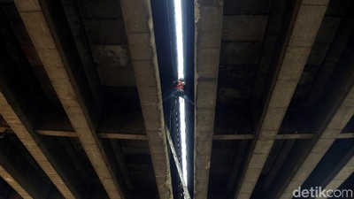 Pekerja Ini Bergelantungan untuk Perbaiki Saluran Air Tol Wiyoto Wiyono