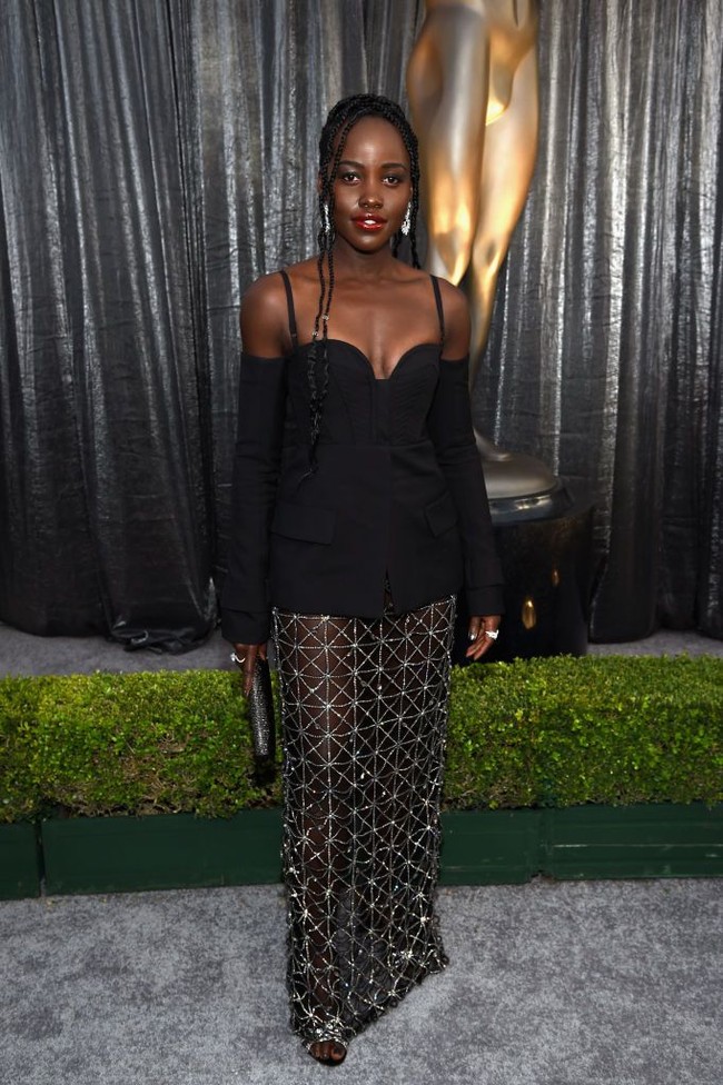 Lupita Nyongo mencuri perhatian di SAG Awards 2019 dengan rancangan unik Vera Wang. Busana serba hitamnya berupa atasan bergaya korset dengan tampilan blazer yang dipadukan dengan rok transparan yang berukirkan berlian dalam motif geometris. (Foto: Getty Images)
