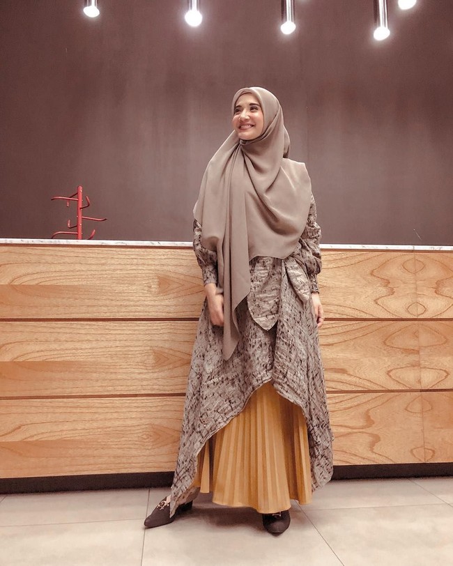 Zaskia Sungkar sering memilih hijab segi empat polos yang banyak dijual di pasaran. Ia memadukannya dengan long outer, dress, dan rok pleats sehingga terlihat lebih trendi. Foto: Instagram Zaskia Sungkar