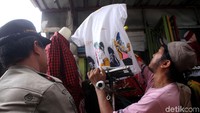 Dagangan milik salah seorang pedagang diturunkan dan diamankan karena telah melanggar aturan dengan berjualan di atas trotoar Tanah Abang.