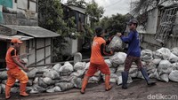 Sejumlah petugas Suku Dinas (sudin) Tata Air dan PPSU Jakarta Utara bekerja sama mengangkut karung pasir untuk mencegah banjir rob di pesisir utara Jakarta, Senin (28/1/2019).