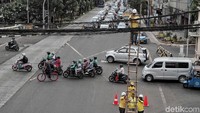 Seorang petugas memanjat tangga untuk merapikan kabel. Sementara beberapa petugas lainnya memegangi tangga dari bawah agar tidak ambruk.