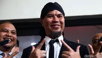 Musisi Ahmad Dhani tersenyum dan berpose salam dua jari saat akan menghadapi sidang vonis ujaran kebencian di PN Jakarta Selatan, Jakarta, Senin (28/1/2019).