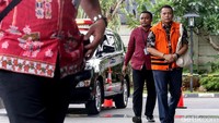 Dudy Jocom tampak tiba di gedung KPK dengan mengenakan baju batik berwarna hitam beserta rompi oranye dengan tetap kedua tangan diborgol.