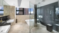 Kamar mandi dibuat elegan dengan nuansa keramik coklat muda dan hitam. Michael Lowdon/Mansion Global.