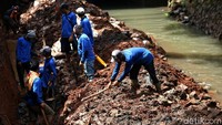 Petugas sedang membongkar dinding turap Kali Pancoran agar lebih kuat menahan debit air.