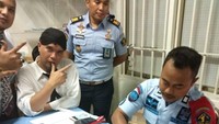 Dhani lagi-lagi berpose salam dua jari sambil menunggu petugas rutan untuk mengurus administrasi penahanannya.Foto: Dok. Istimewa