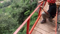 Terlihat tim pembuatan spot foto selfi sedang meniti besi rangkaian jembatan yang akan dijadikan wahana wisata baru setinggi 25 meter di Tebing Gumuk Reco. (Aji Kusuma/detikTravel)