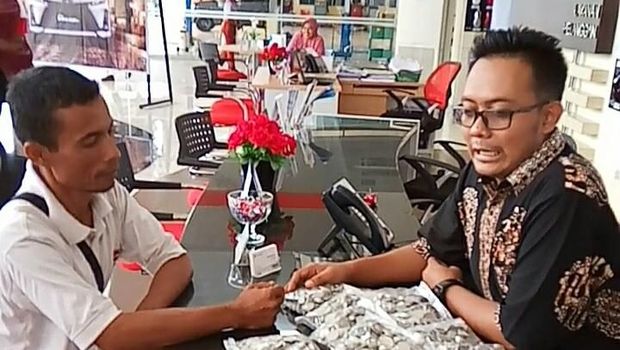 Tirta tengah menyerahkan uang recehnya untuk beli mobil