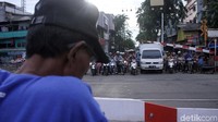 Warga menunggu kereta melintas.