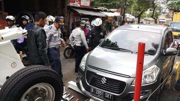 Mobil Jazz diderek karena parkir di lokasi larangan parkir.