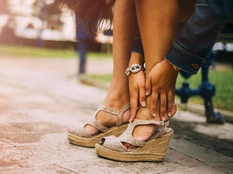 A young woman with feet pain from gih heels