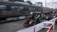 Kendaraan menunggu kereta melintas di perlintasan Jembatan Besi Raya.