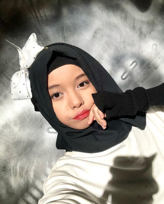 Gaya hijabnya yang khas adalah hijab tumpuk di kepala dengan pemakaian aksesori seperti bros pita hingga bando. Ia berbagi tutorial hijabnya di Youtube pribadinya. Foto: Dok. Youtube Fatimah Halilintar