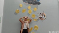 Ada pula gambar sebuah shower yang mengeluarkan koin-koin emas. Traveler bisa berpose seolah-olah tengah mandi dengan emas (Anggi/detikTravel)