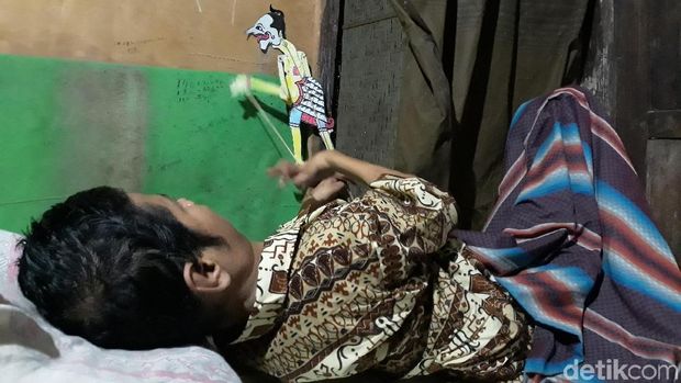 Mbah Un saat memainkan wayangnya di sela belajar bersama di rumahnya. 