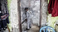 Petugas melakukan fogging di rumah-rumah warga.