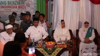 Setiba di panggung kecil, Jokowi duduk bersebelahan dengan KH Maimoen Zubair, yang akrab disapa Mbah Moen, dan istrinya.